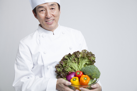 Cook smiling with a vegetableの写真素材