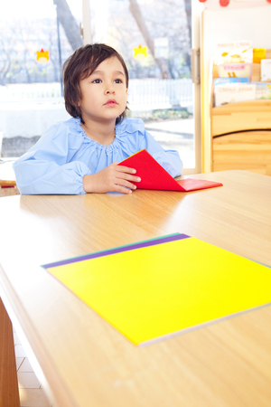 Kindergarten boy fold origamiの写真素材