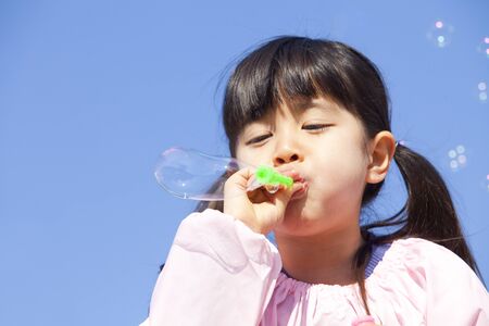 Kindergarten girls to wipe the soap bubbleの写真素材