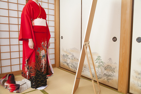 Woman in dressing to stand in front of the full-length mirrorの写真素材
