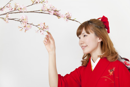 Women kimono figure to touch the cherry treeの写真素材