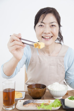 Housewife to hold out the omeletの写真素材
