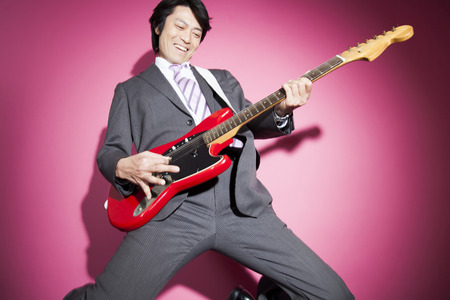 Businessmen play guitarの写真素材