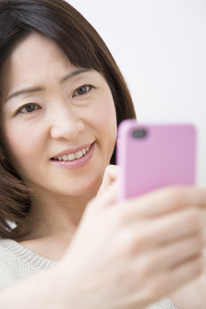 Middle Lady to work with Smartphonesの写真素材