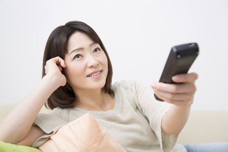 Middle women using the remote controlの写真素材