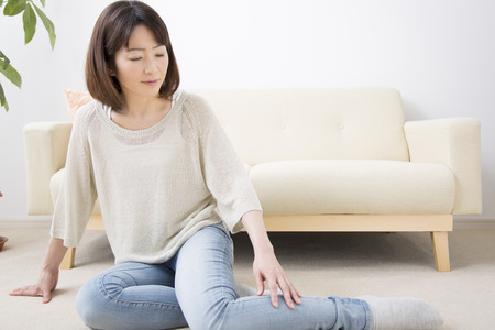 Middle woman sitting on carpetの写真素材