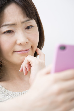 Middle Lady to work with Smartphonesの写真素材