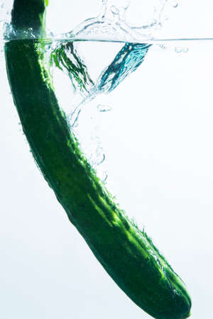 Cucumber diving into waterの写真素材