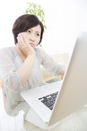 Middle women who do not know how to use a personal computerの写真素材