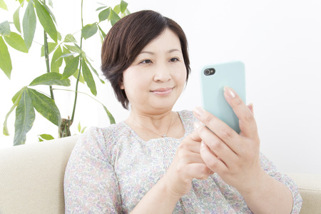 Middle Lady to work with Smartphonesの写真素材