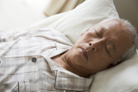 Hand of senior men who sleep in the nursing bedの写真素材