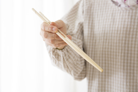 The hands of the senior women with chopsticksの写真素材