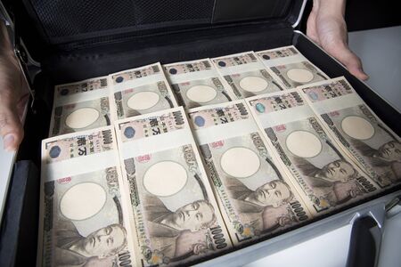 Men show a container with a lot of money in attache case