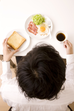 Businessman eating breakfastの写真素材