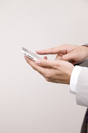 Businessman fiddling with mobile phoneの写真素材
