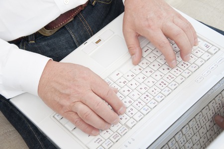 Hand of senior men who use a laptopの写真素材