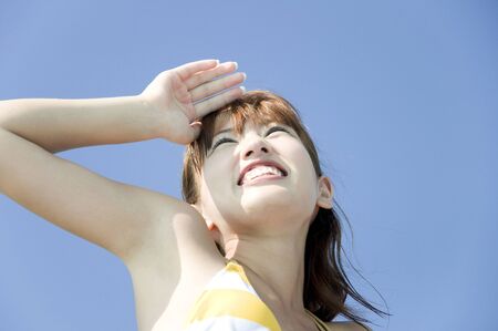 Swimsuit women who look up at the skyの写真素材