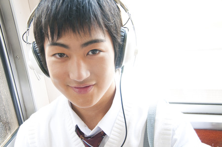 High school boy to headphones on a trainの写真素材