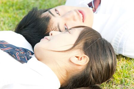 High school student couple on the lawnの写真素材