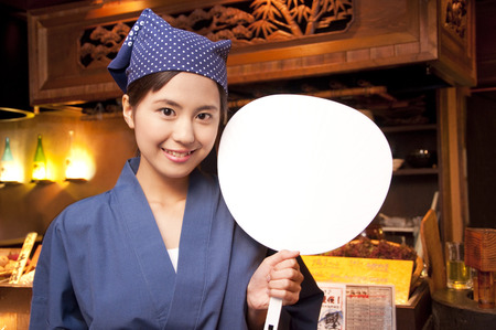 Tavern clerk smiling with a fanの写真素材
