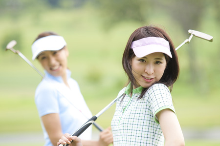 2 women smiling with a putterの写真素材
