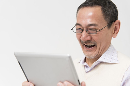 Senior man laughing with Tablet PCの写真素材