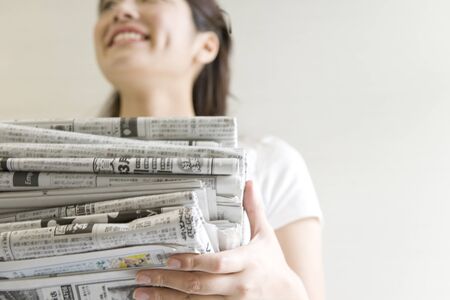 Women who have a bunch of newspaperの写真素材