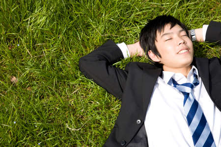 Businessman to lie down on the lawnの写真素材