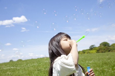 Girl playing with bubblesの写真素材