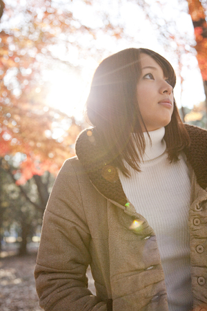 Woman smiling under the autumn leavesの写真素材