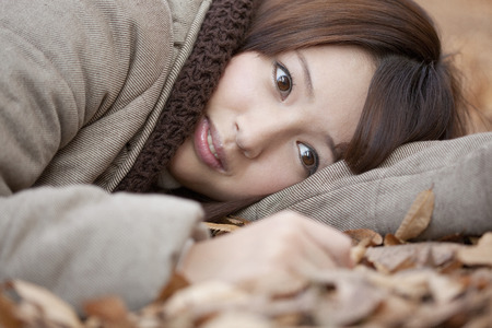 Women who plops itself down on the fallen leavesの写真素材