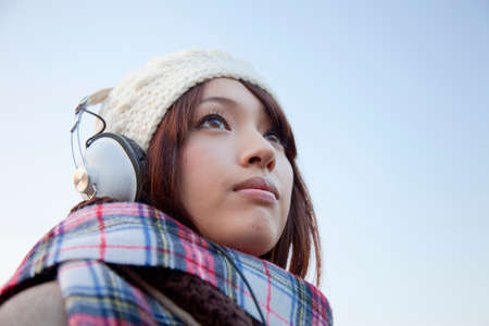 Woman smiling and putting on headphonesの写真素材