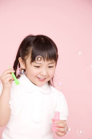 Children playing with soap bubbleの写真素材