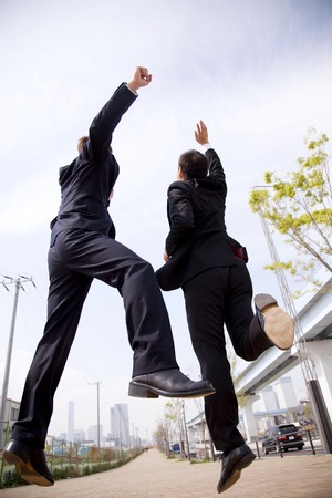 Two businessmen to jumpの写真素材