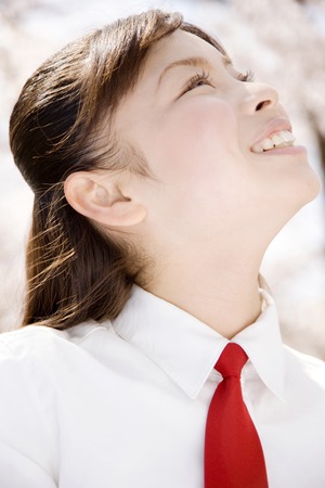 Schoolgirl smiling under the cherry treeの写真素材