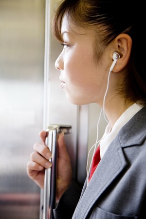 High school girl listening to music in a trainの写真素材