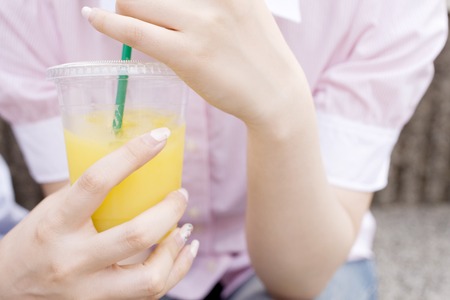Hand of woman with orange juiceの写真素材