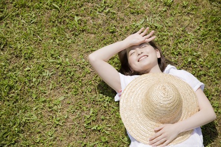 Women who are lying down on top of the lawnの写真素材