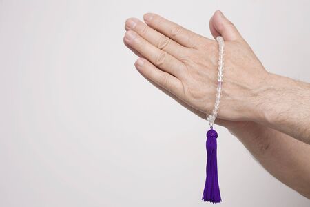 Hand of the woman who worship with a rosaryの写真素材