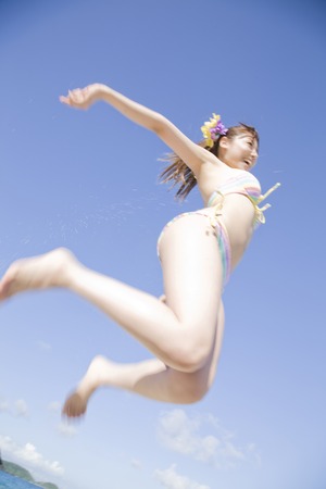 Women's swimsuit to jump on the beachの写真素材