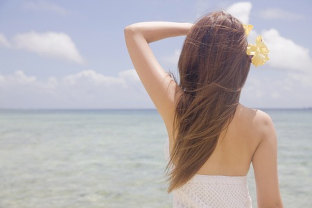 Back shot of a woman standing in the waterの写真素材