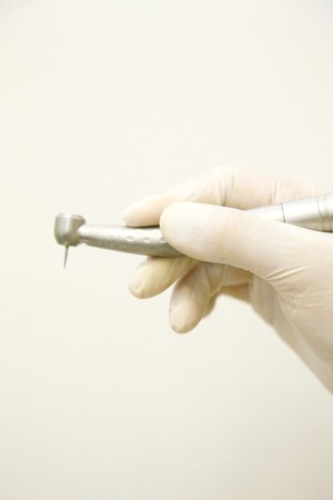 Hand of the dentist with a cutting deviceの写真素材