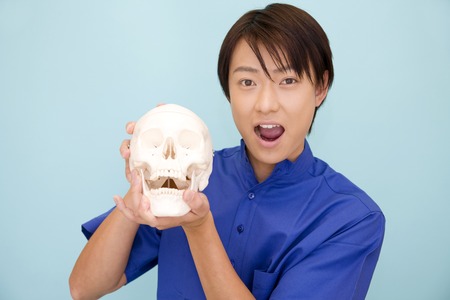 Male dentist with a time skeletonの写真素材