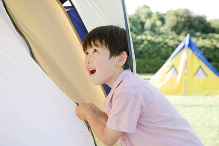 Boy to open and close the tent zipperの写真素材