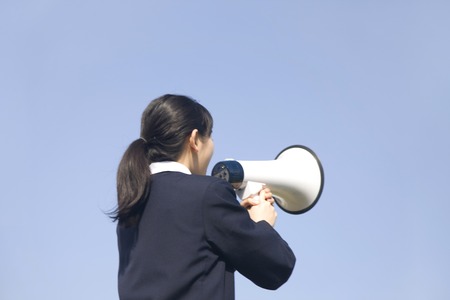 Junior high school girls to issue a loud loudspeakerの写真素材