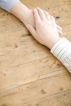 An old couple holding hands at handの写真素材