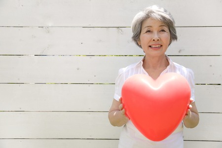 Senior women with heart balloonsの写真素材
