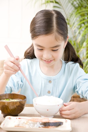 Girl eating white riceの写真素材