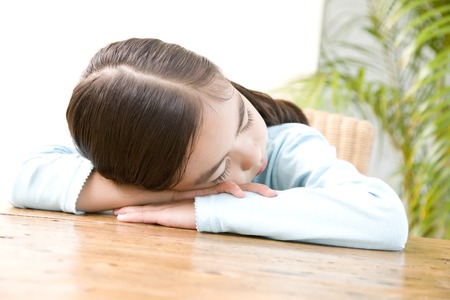 Girl sleeping in deskの写真素材