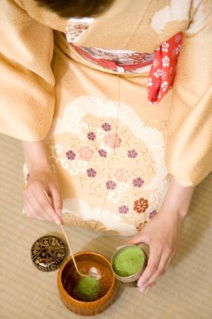 Women who put the powdered green tea in cupの写真素材